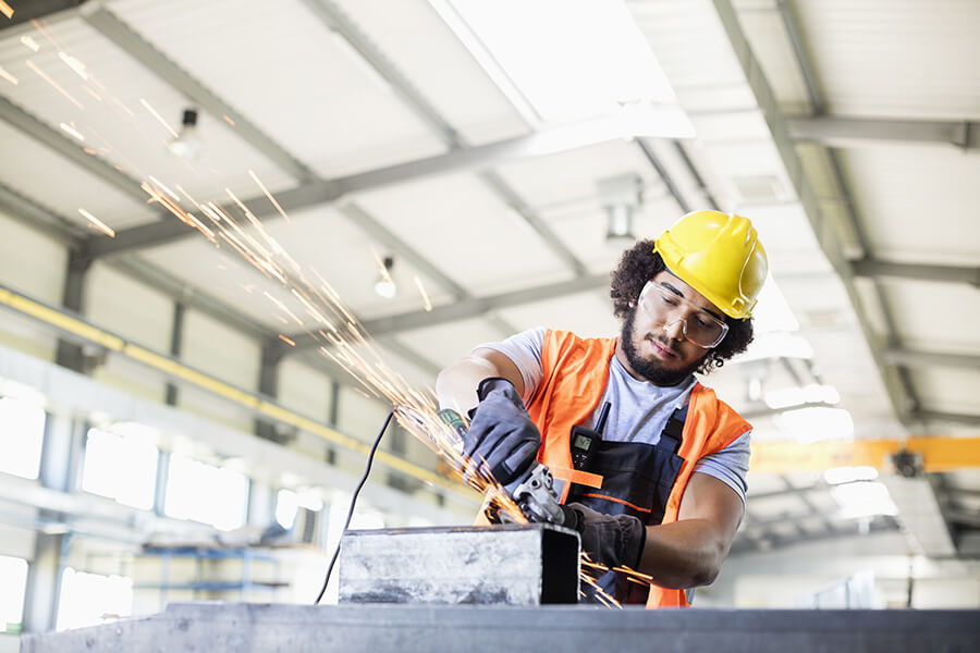 A construction worker cutting steel on site