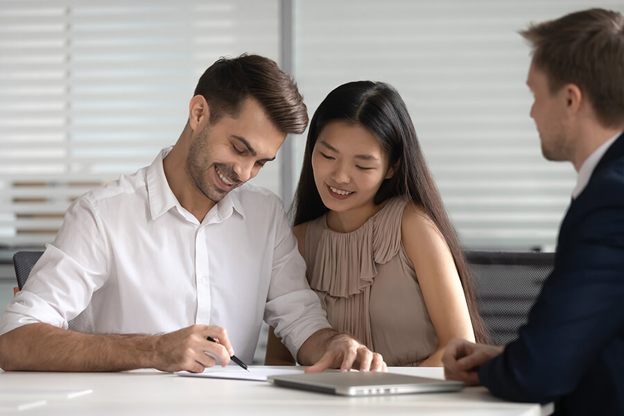 A young couple reviewing paperwork with an adviser